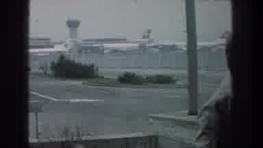ZURICH SWITZERLAND-1976: Blue And White Shuttle Bus Drives Past Parked Jet