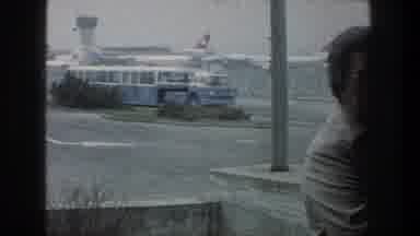 ZURICH SWITZERLAND-1976: View Of Blue Shuttle Bus Driving Past Parked Jet Planes