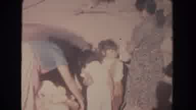 New Mexico (1951): Family Woman Places Cloth Into Large Stone Containers In City