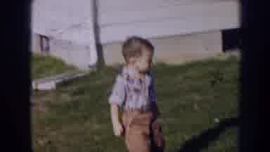 Nebraska (1956): Little Boy Walking Around In The Grass Outside A House
