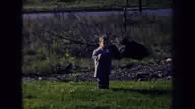 Nebraska (1956): Toddler Wearing Light Blue Coat Picks Up Red Hat From Ground On A