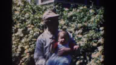 Tustin Wisconsin (1964): Man Carrying Baby And Helping Same Baby Walk A Boy