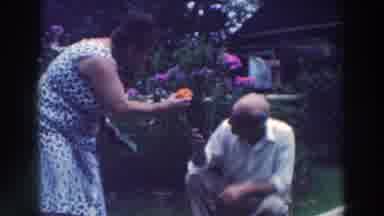 Tustin Wisconsin (1964): A Woman Standing And A Man Squatting Showing Off Their
