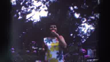Tustin Wisconsin (1964): Woman Wearing White Flower Dress Eats Red Object On A