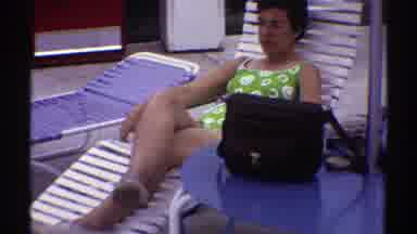 Nebraska (1969): Woman Wearing Green Swimwear Relaxes In White Pool chair On A