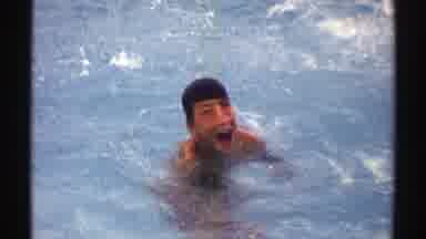Nebraska (1969): Boy In Swimming Pool Waves At Camera On A Clear Day