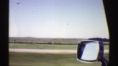 Nebraska (1969): Passing View Of Green Fields And Small White Objects On A Bright