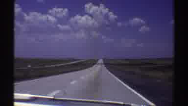 Nebraska (1969): View Of Light Grey Asphalt Highway Blue Sky And White Clouds On A