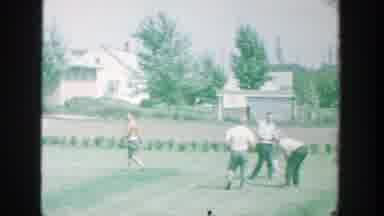 Michigan (1964): People Picking Up Objects Near Blue House On A Sunny Day