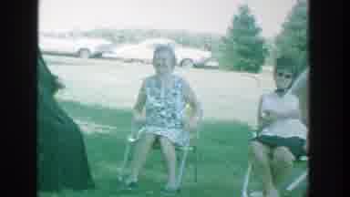 Michigan (1964): Gathering In A Park Of People Sitting On Chairs And Benches In