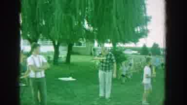 Michigan (1964): People Sit In Chairs And Walk Around A Field While Eating On A