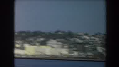 California (1961): Passing View Of Blue Ocean Water And Grey Ship On A Sunny Day