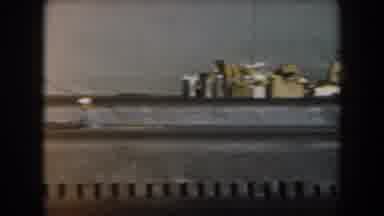 California (1961): Passing View Of Small Grey Boat On A Clear Day