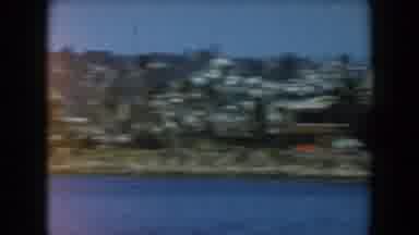 California (1961): Buildings And Homes From A Town Dot The Forested Hills Above