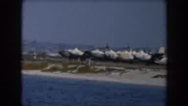 California (1961): Several Airplanes Lined Up On A Runway Near The Water