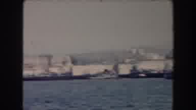 California (1961): Clip Of Docked Battleships In The Harbor With Buildings In The