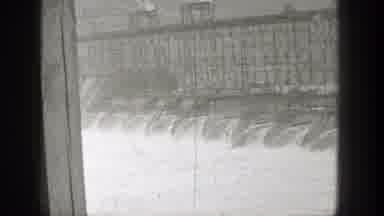 Washington (1938): View Of Dam Releasing Water And Two Objects Traveling On Bridge