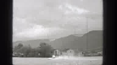 Washington (1938): A Very Fast Motorboat On A Lake With Houses And Trees And