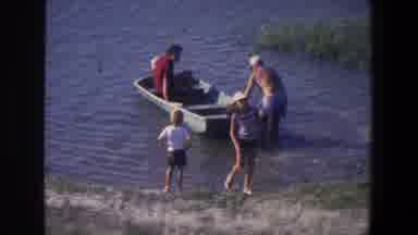 Saint Paul Minnesota (1971): Two Adults Get Into A Small Boat On The Water While