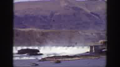 California (1938): An Open Dam Pouring Out Water With Mountains In The Background