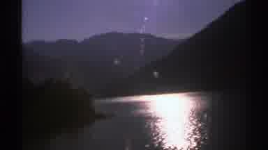 Norway (1976): Sun Shining On Mountain Creek With Pine Trees Dark Skies