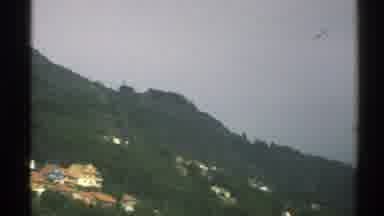 Norway (1976): Distant Greenery And Mountainside Homes Against A Dark Grey Sky