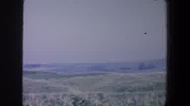 Iowa (1959): A Field In The Countryside With Mountains In The Background