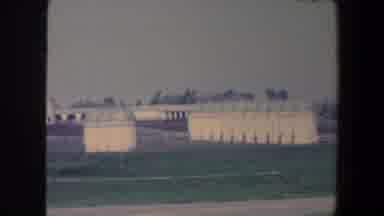 Iowa (1959): A Row Of Silos On A Farm Stand Near Pens With White Fences And White