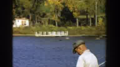 Wisconsin-1957: People Fishing By Lake With Classic Cars And Autumn Trees