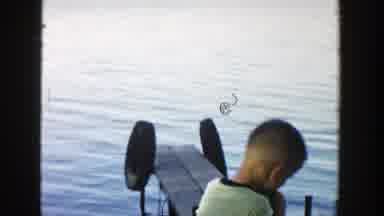 Wisconsin (1957): Little Boy By The River Playing With Two Dogs Near A Dock