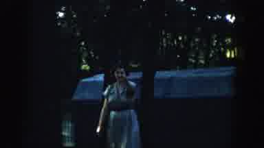 Wisconsin (1957): Woman In A Dress Walks Away From A Building Points At The Camera
