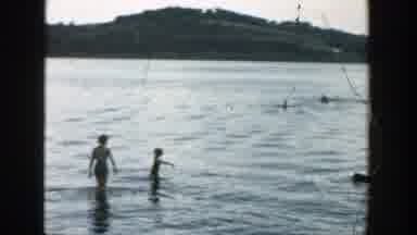 Wisconsin-1957: A Group Of Adults And Children Swimming In The Shallow Parts Of