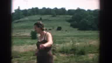 Wisconsin (1957): Woman Wearing Pink Swimwear Runs In Water On A Clear Day
