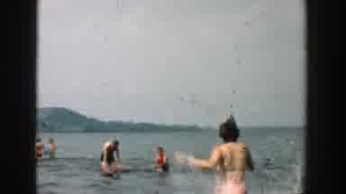 Wisconsin (1957): People Bathing In A Lake With Bathing Suits And A Woman Sitting