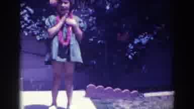 North Hollywood California (1961): Girl Wearing Blue Dress Taps Chest With Hand On