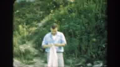 Connecticut (1947): Man Folding Sheet With Child Passing In Front Of Him And