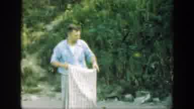 Connecticut (1947): A Man Walking In Front Of A Wooded Area Folding A Blanket