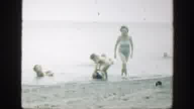 Connecticut (1947): Woman Wearing Blue Swimwear Walks On Beach Sand On A Clear Day