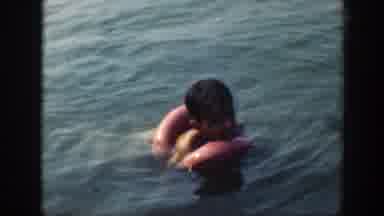 Connecticut (1947): Boy Wearing Red Shorts Stands In Shallow Lake Water On A Clear