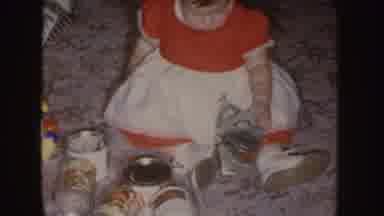 Nebraska (1955): Baby Girl In Dress Sitting On Carpeted Floor With A Pile Of