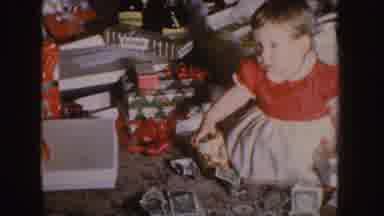 Nebraska (1955): A Baby Holding A Drink Sited In A Room Full Of Wrapped Gifts