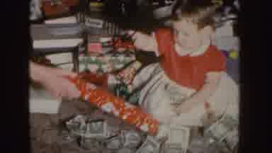 Nebraska (1955): Baby Opening A Christmas Gift With A Green Bow
