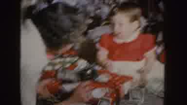 Nebraska (1955): A Young Toddler Opens Christmas Presents With Help From Older