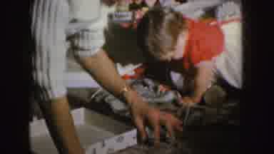 Nebraska (1955): Woman Wearing White Sweater Helps Toddler Wearing White Dress