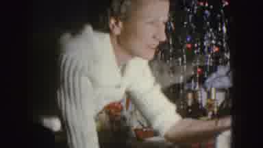 Nebraska (1955): Woman Wearing White Sweater Plays With Infant Wearing Red And
