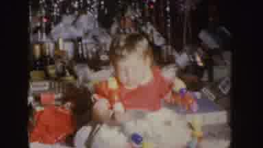 Nebraska (1955): Baby Wearing Red And White Dress Sits Near Christmas Tree With