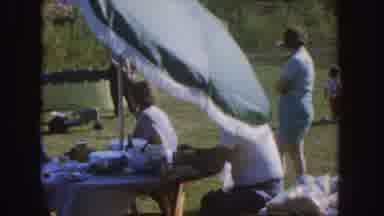 Nebraska (1955): Group Of People Sitting On The Green Grass On A Sunny Day