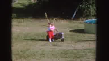 Nebraska (1955): A Little Girl Dressed In Red Pants Plays On A Toy Tractor On A