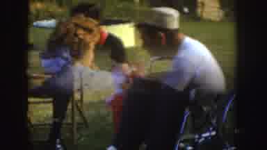 Nebraska (1955): Baby Girl Strolling Among Family Members While Eating At A Garden