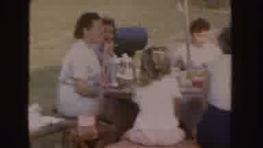 Nebraska (1955): A Family Sitting At A Wooden Table In The Green Garden Next To A